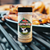 12 oz bottle of Cluckalicious poultry seasoning on a table with grilled chicken