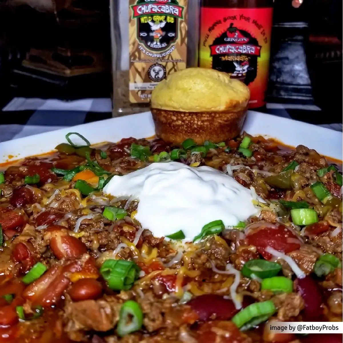 bottle of marigate with a bowl of chili and cornbread